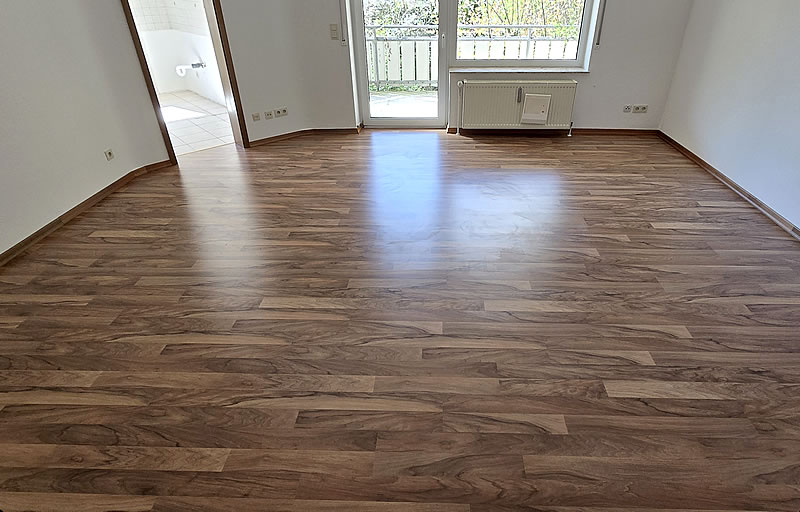 Neu verlegter Fußboden nach Wohnungsrenovierung - Handwerker Robert Schäke aus Bad Pyrmont, ihr Allround Handwerkerservice für Dienstleistungen in Haus und Garten um Hameln und Bad Pyrmont, Handwerker Allrounder für Renovierung, Modernisierung, Sanierung im Raum Hameln Pyrmont. Wasserschadensanierung und Kaminsanierung durch den Handwerkerservice Robert Schäke. Neu verlegter Bodenbelag in einem renovierten Wohnraum mit weissen Wänden und einem Fenster im Hintergrund.